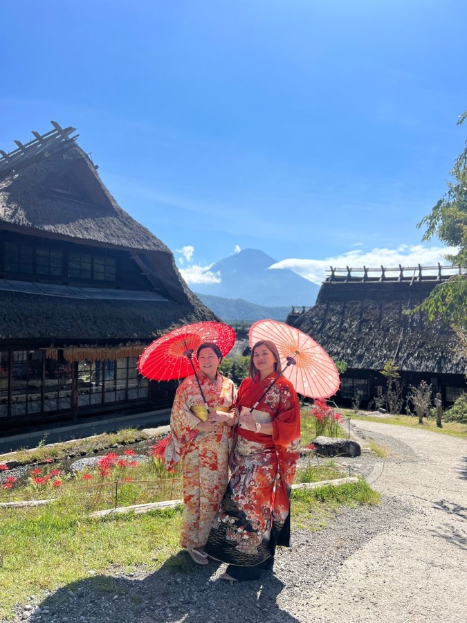 Women in kimono with Mount Fuji and a traditional village